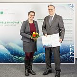 Die Präsidentin und Dr. Christoph Knieke stehen nebeneinander und zeigen die Urkunde nach der Übergabe.
