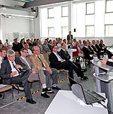 Person an einem Rednerpult hält eine Präsentation