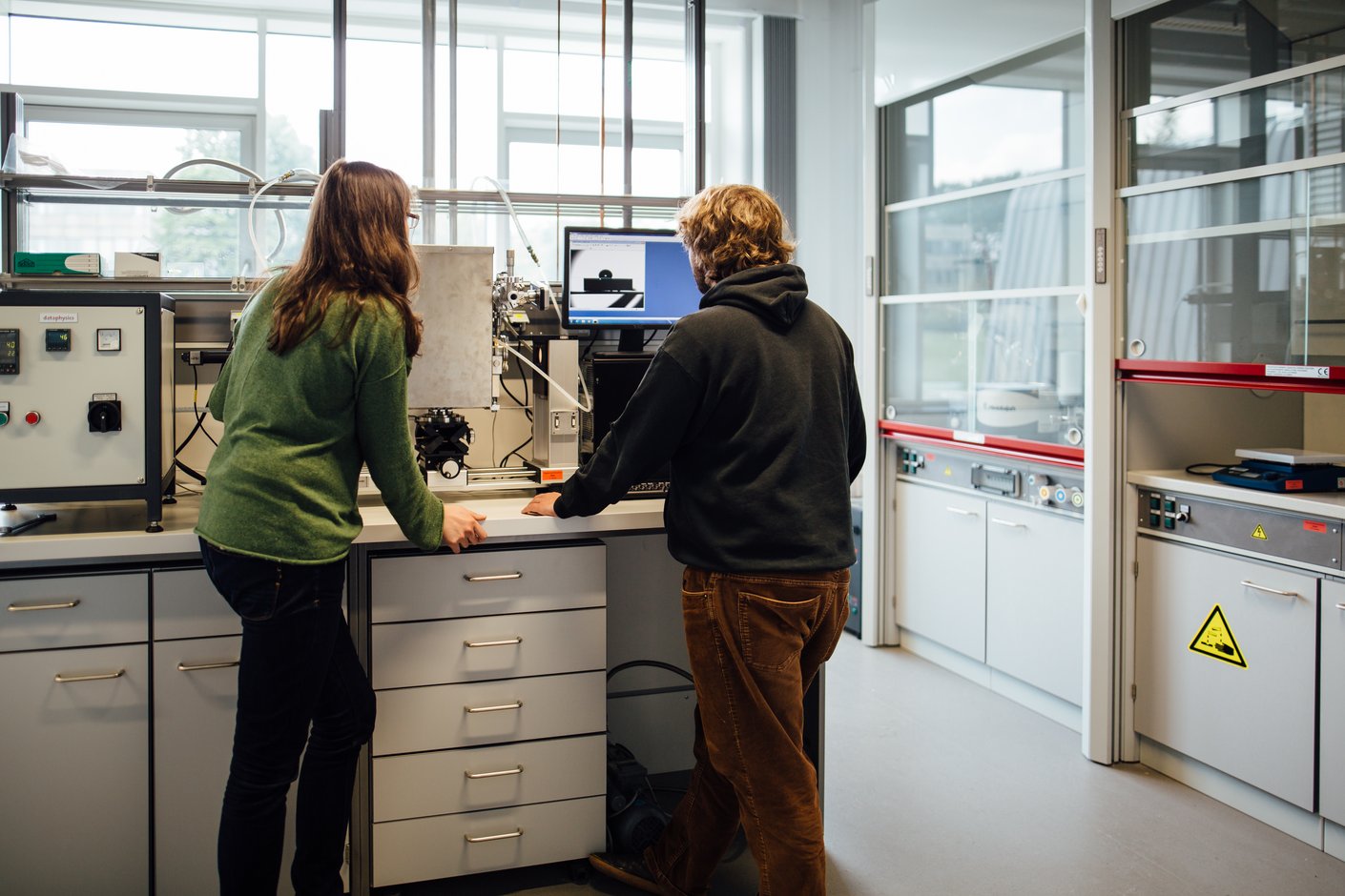 Zwei Personen schauen auf ein Monitor im Labor