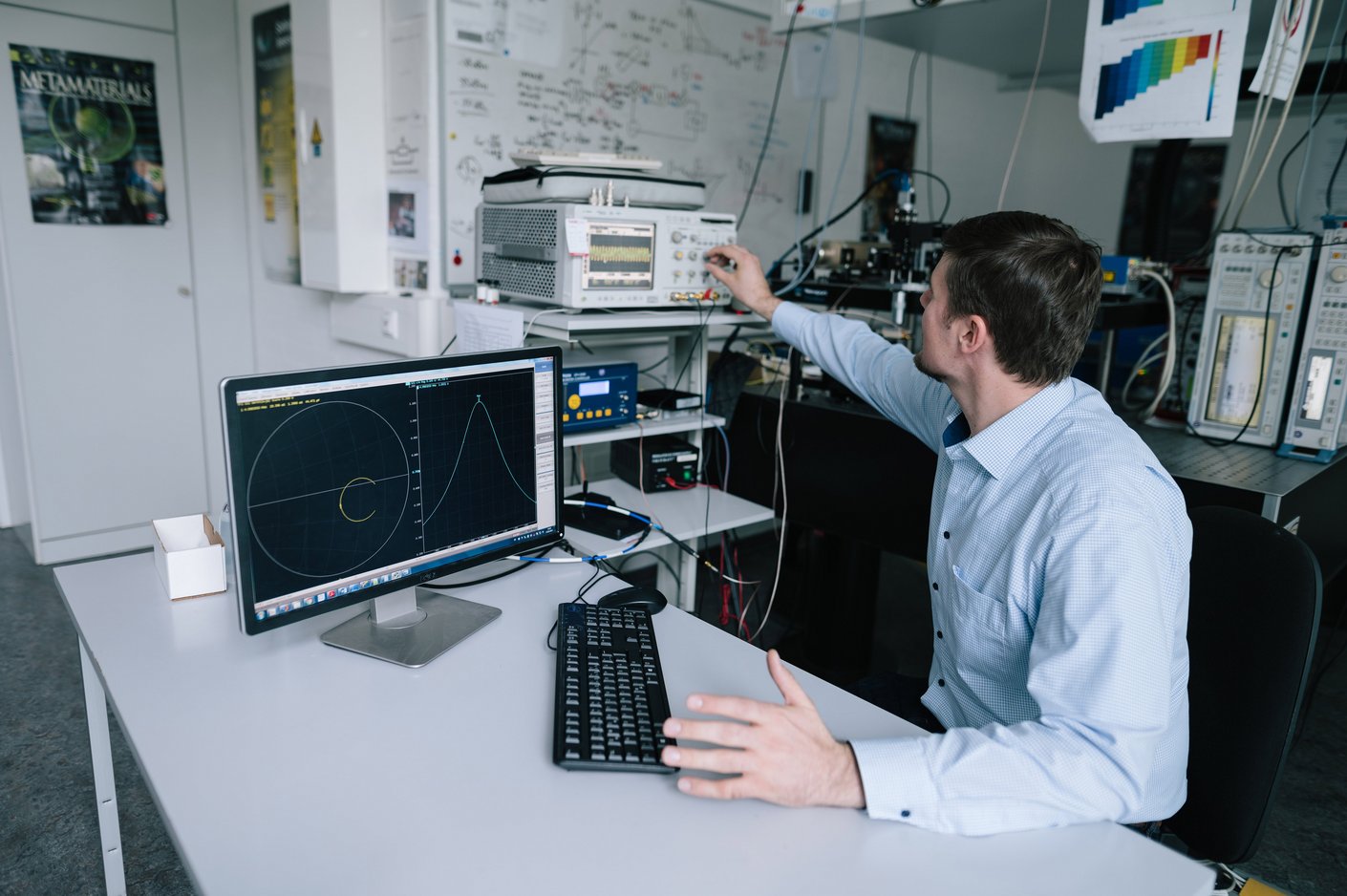 Person sitzt am Schreibtisch und dreht an Reglern