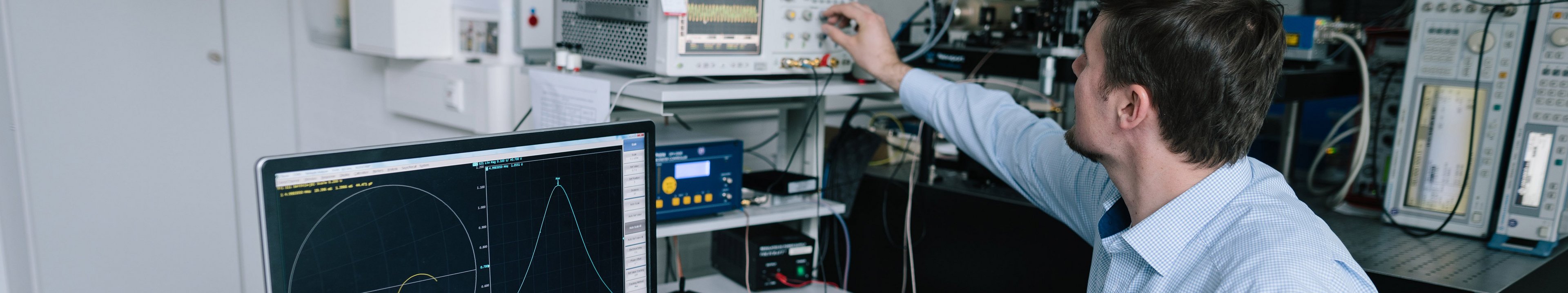 Person sitzt am Schreibtisch und dreht an Reglern