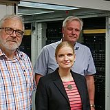 Personen stehen vor Serverschränken