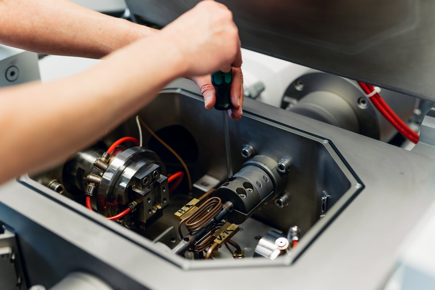 Hände schrauben in einer Maschine