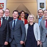 Personen stehen nebeneinander auf der Treppe