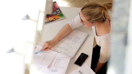 Luftansicht auf eine Gruppe von Studierenden die am Tisch sitzen und lernen
