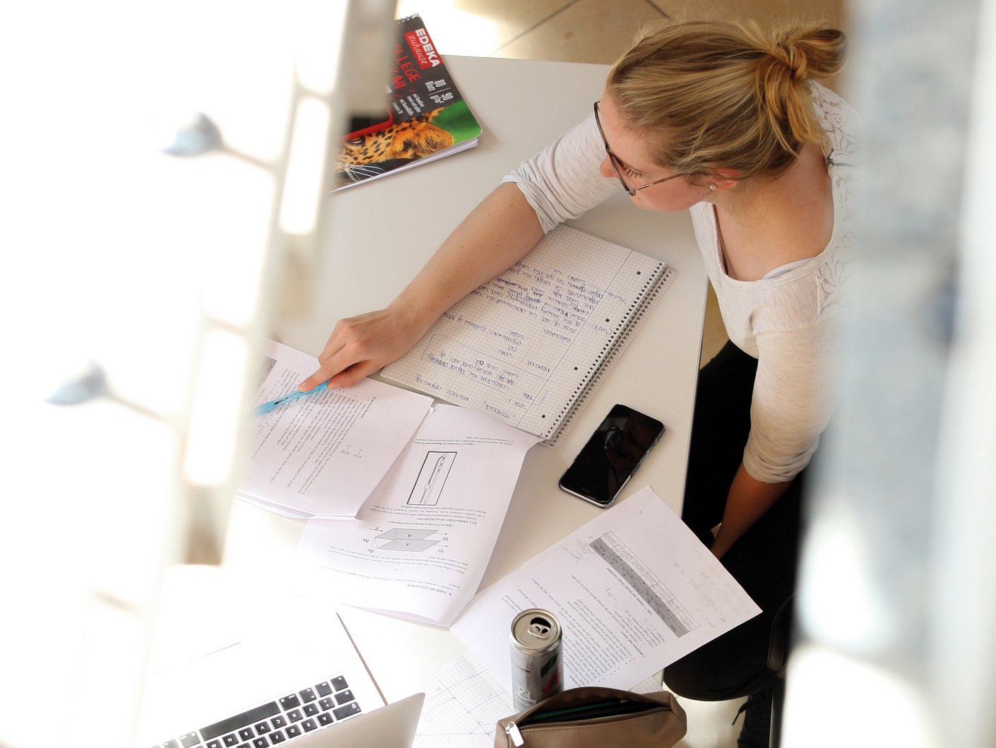 Luftansicht auf eine Gruppe von Studierenden die am Tisch sitzen und lernen