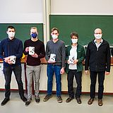 Vier Personen mit Kopfhörerboxen stehen neben anderen